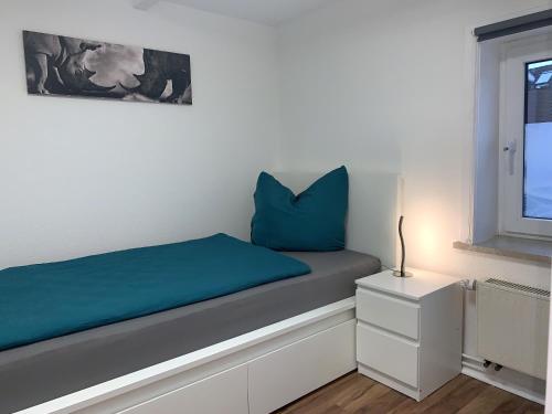 a bedroom with a bed with blue pillows and a window at Ferienwohnung Gaussblick in Dransfeld