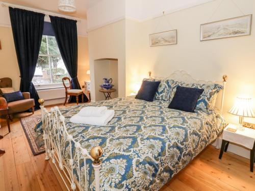 a bedroom with a bed with a blue and white bedspread at Little Mornington in Malvern Link