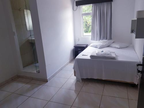 a bedroom with a bed and a window and a shower at Hotel Salto do Norte in Blumenau