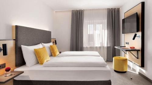 Ένα ή περισσότερα κρεβάτια σε δωμάτιο στο Stadthotel Oberndorf - 24h Self Check-In Terminal