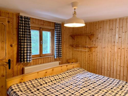 a bedroom with a bed in a room with wooden walls at Schmirnhaus in Schmirn