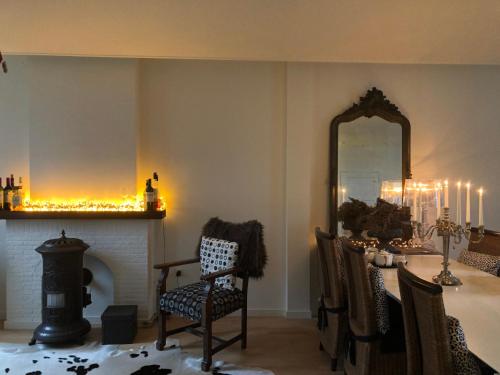 a dining room with a table and a mirror at B&B de Tol in Hulst