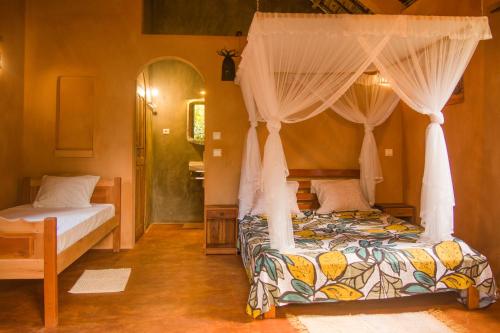 a bedroom with two beds and a canopy bed at Villa Paradis in Sainte Marie