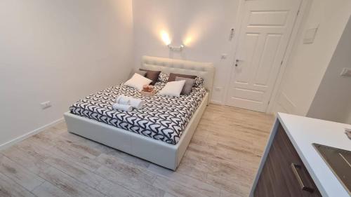 um quarto branco com uma cama com almofadas em BARBARA Classy Apartment 101 em Siracusa