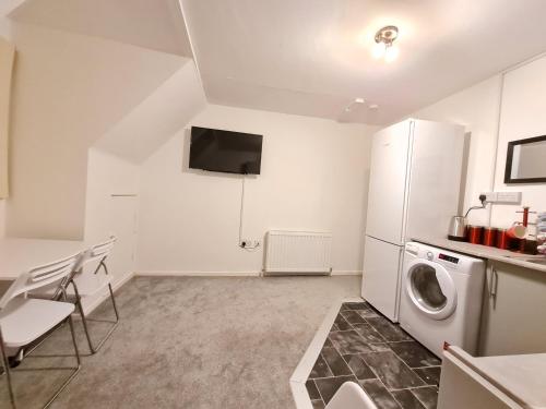 a kitchen with a refrigerator and a washing machine at Grace Apartments - Living Stone 2 in Ashford