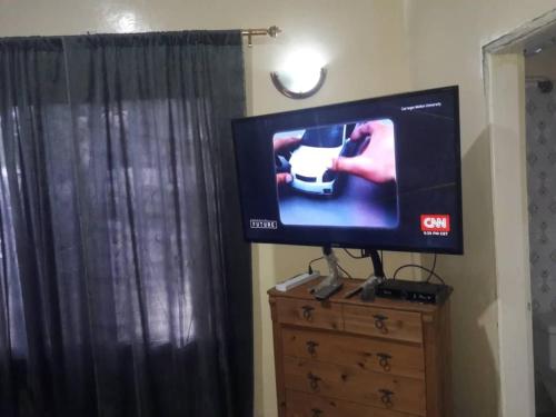 a flat screen tv sitting on a dresser at Remarkable 4-Bed with air conditioning in Brikama in Brikama