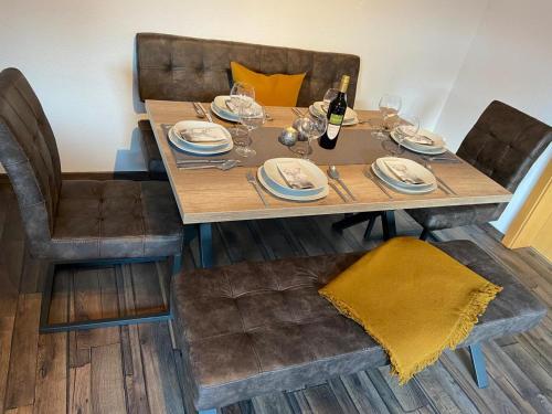 a wooden table with chairs and a bottle of wine at Ferienwohnung "Apartment Sunlife Winterberg" 4 Sterne in Winterberg