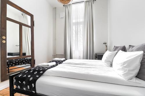 ein Schlafzimmer mit einem großen Bett und einem Spiegel in der Unterkunft Apartament Absynth in Stettin