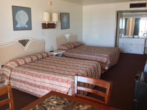 ein Hotelzimmer mit 2 Betten und einem Fenster in der Unterkunft Sea Shell Inn on the Beach in Corpus Christi