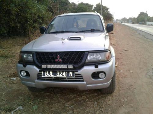 a white car parked on the side of a road at Remarkable 4-Bed with air conditioning in Brikama in Brikama