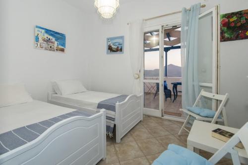 a bedroom with two beds and a balcony at Milos Sunset Home in Tripiti