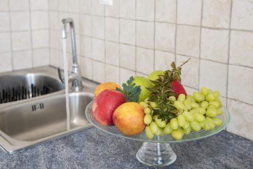 a bowl of fruit on a counter next to a sink at Milos Sunset Home in Tripiti