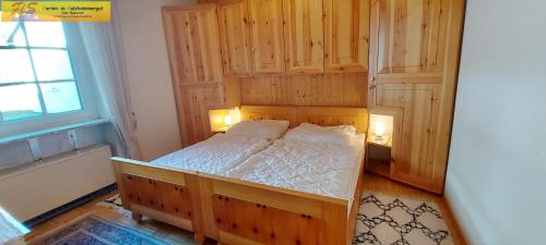 een slaapkamer met een houten bed met verlichting bij Ferienhaus Almrausch by FiS - Fun in Styria in Tauplitz