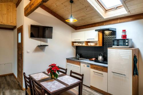a kitchen with a table and a refrigerator at Apartament Zagroda in Czarny Dunajec
