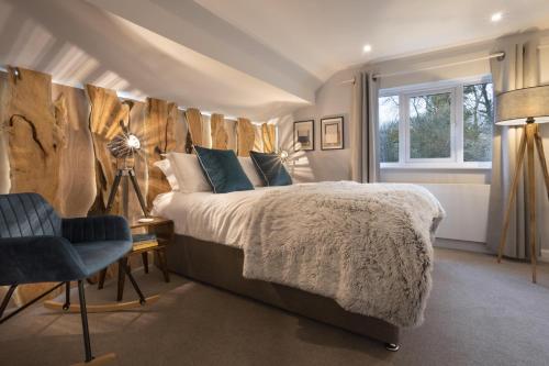 1 dormitorio con 1 cama grande y pared de madera en Woodlands Family Retreat Windermere with Hot Tub and Sauna, en Windermere