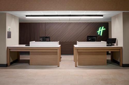 a lobby with two desks and a cross on the wall at Holiday Inn & Suites Boston Peabody by IHG in Peabody