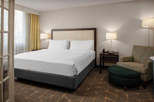 a hotel room with a bed and a chair at Holiday Inn & Suites Boston Peabody, an IHG Hotel in Peabody