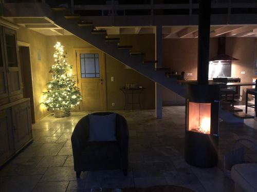a living room with a christmas tree and a staircase at Le champ Madame in Stavelot