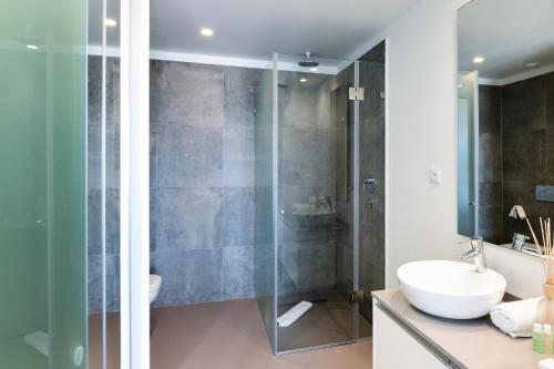 a bathroom with a glass shower and a sink at Oscar Concept Apartments in Lisbon