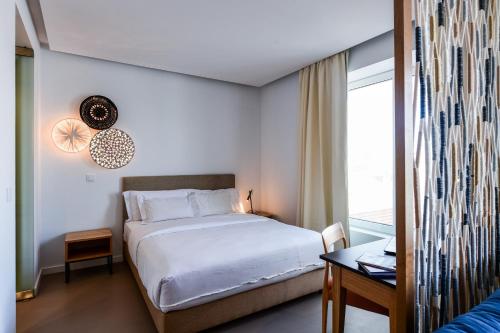 a bedroom with a white bed and a window at Oscar Concept Apartments in Lisbon