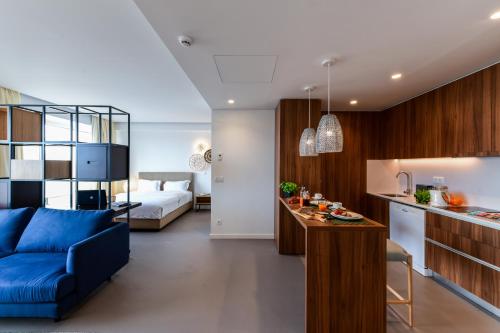 ein Wohnzimmer und eine Küche mit einem blauen Sofa in der Unterkunft Oscar Concept Apartments in Lissabon