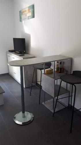 un escritorio con 2 sillas y un ordenador. en charmant studio dans résidence neuve et calme, en Corte