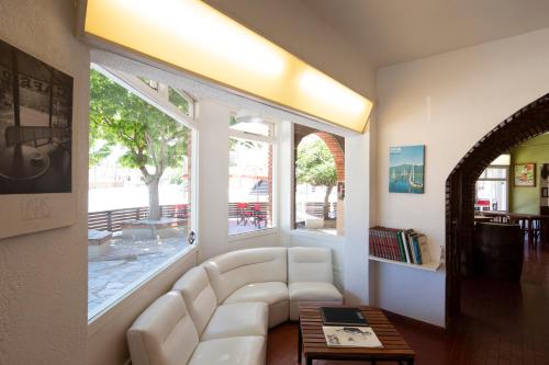 sala de estar con sofá blanco y ventana grande en Hotel Arcoiris en Villa Gesell