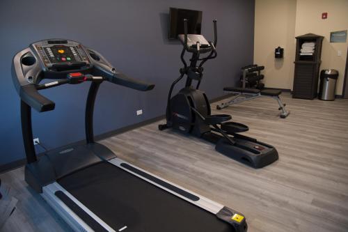 a gym with two exercise bikes and a treadmill at Cobblestone Inn & Suites - Forest City in Forest City