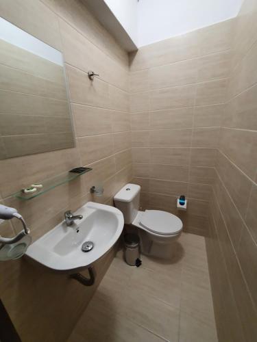 a bathroom with a white sink and a toilet at City Center Athenes rooms in Athens