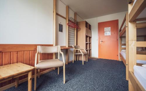 a room with a desk and chairs and a bed at Maxon Pavillon by Mountain Hotels in Davos