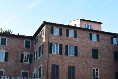 an old red brick building with a tower on top at Al Carmine Apartments Towers view with AC in Lucca