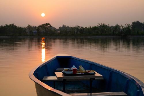 a blue boat with a tray of food on the water at Lumbini Palace Resort in Lumbini