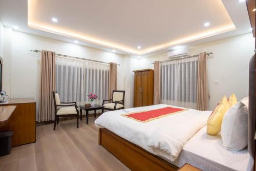 a bedroom with a bed and a table and chairs at Lumbini Palace Resort in Lumbini
