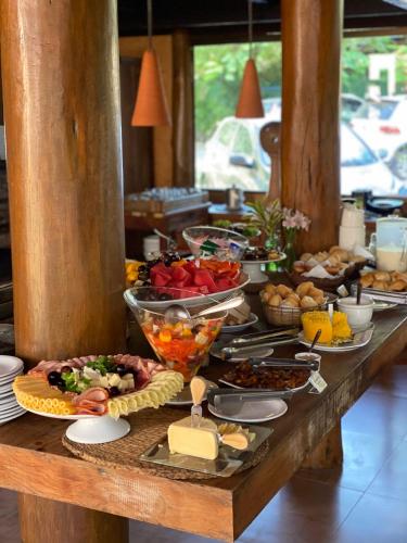 Un buffet con muchos tipos diferentes de comida en una mesa. en Pousada Casa de Praia, en Praia do Forte