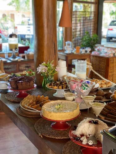 Una mesa con muchos tipos diferentes de comida sobre ella. en Pousada Casa de Praia, en Praia do Forte