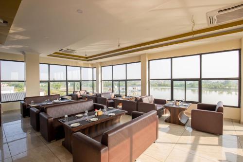 a restaurant with tables and chairs and large windows at Lumbini Palace Resort in Lumbini