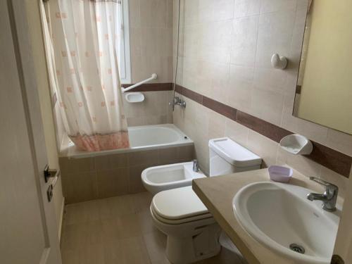 a bathroom with a toilet and a sink and a tub at Silenios in Pinamar