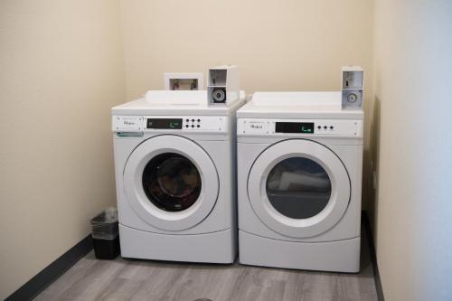 two washing machines sitting next to each other in a room at Cobblestone Inn & Suites - Forest City in Forest City