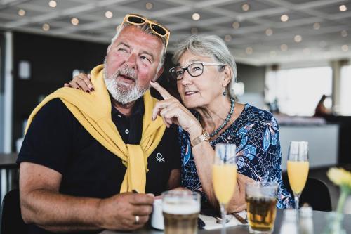 a man and a woman sitting at a table with drinks at Hotel Atlantic in Aarhus