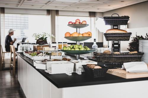 a buffet with several tiers of food on a counter at Hotel Atlantic in Aarhus