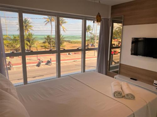 a bedroom with a bed with a view of the beach at Apartamento Tambau a Beira Mar in João Pessoa