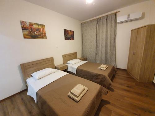 una camera d'albergo con due letti e una finestra di Athens Center Solomou rooms ad Atene