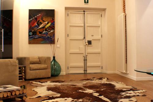 a living room with a chair and a door at Dimora di Charme Cassaro 168 in Marsala
