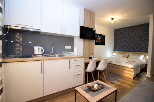 een keuken met een wastafel en een bed in een kamer bij Villa Diamond in Mostar