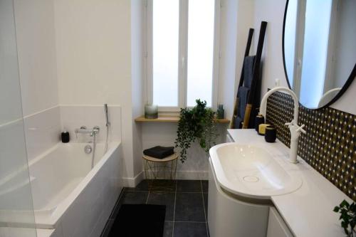 une salle de bain avec une baignoire et un lavabo et une baignoire dans l'établissement 85 m2 centre ville 2 mn vieux Port au calme, à Marseille
