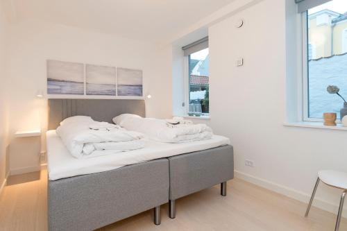 uma cama com toalhas brancas num quarto em Harbour Walk em Sonderborg