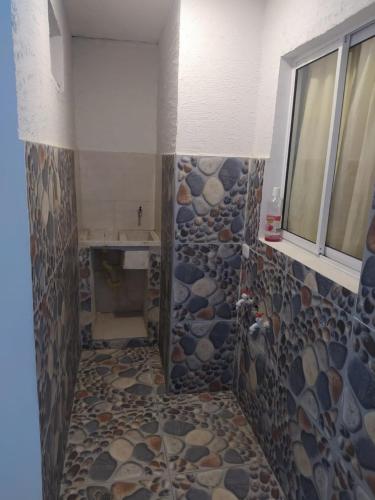 a bathroom with a shower with rocks on the wall at Emvacamo' in Taganga