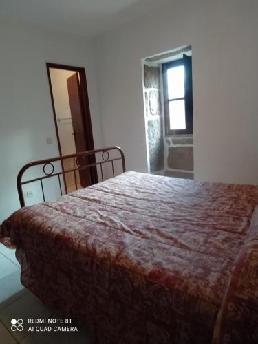 a bedroom with a bed and a mirror and a window at Casa Prado de Mó in Arcos de Valdevez