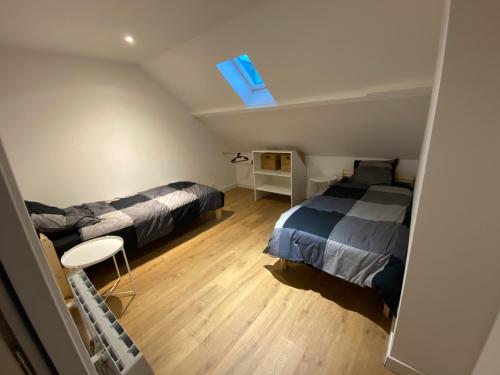 a attic bedroom with two beds and a skylight at La Sècherie de Waldam pour 4 personnes in Oye-Plage