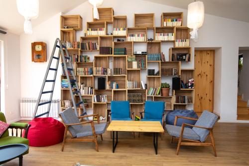 a room with chairs and a book shelf with books at Vardeni Guesthouse in Hrazdan